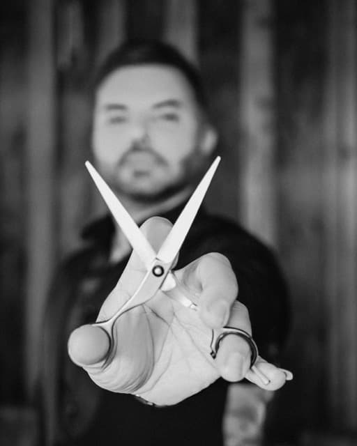 Tony from TJ Barber presenting scissors to camera